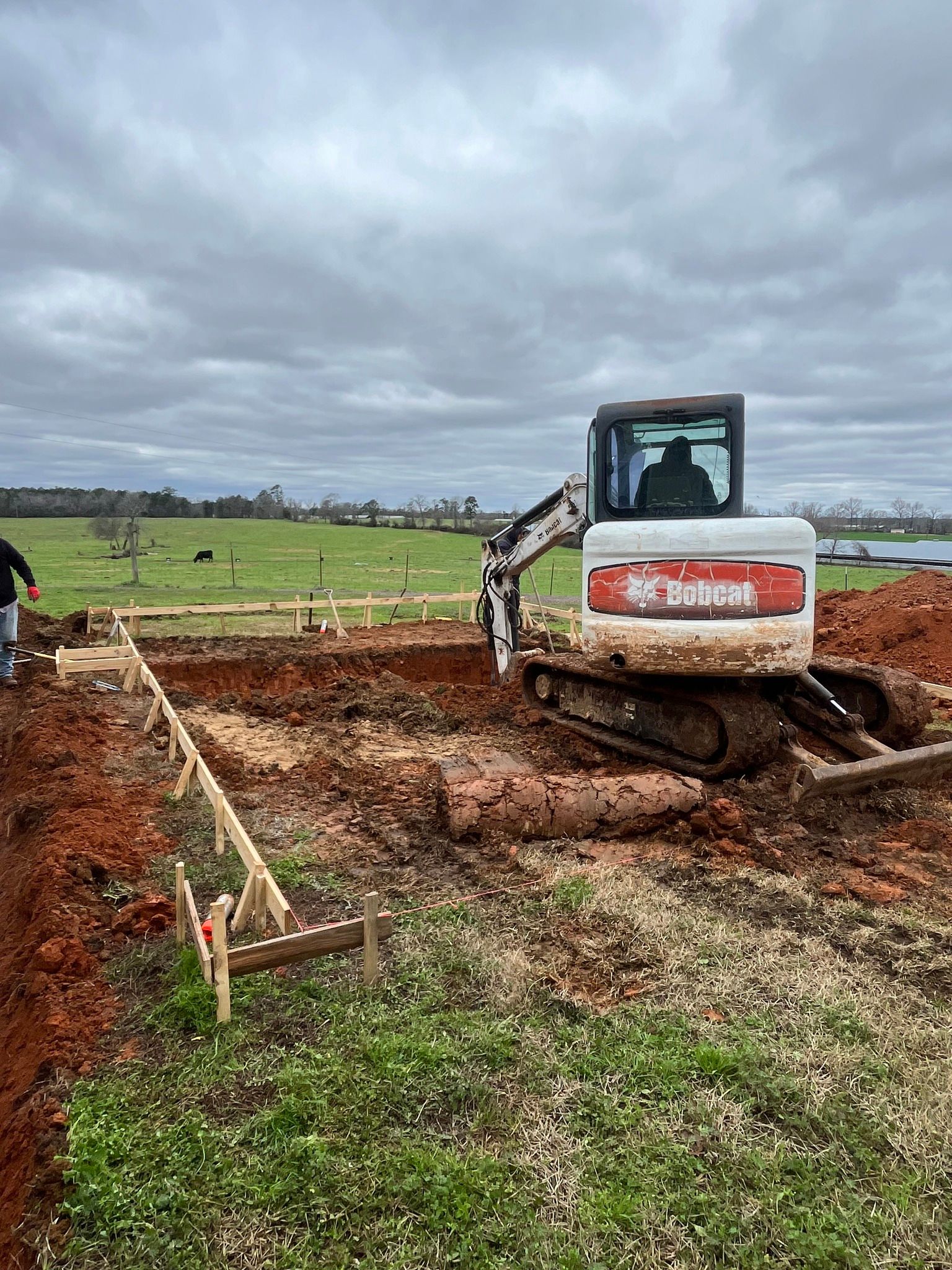 A bulldozer is digging a hole in the dirt in a field.