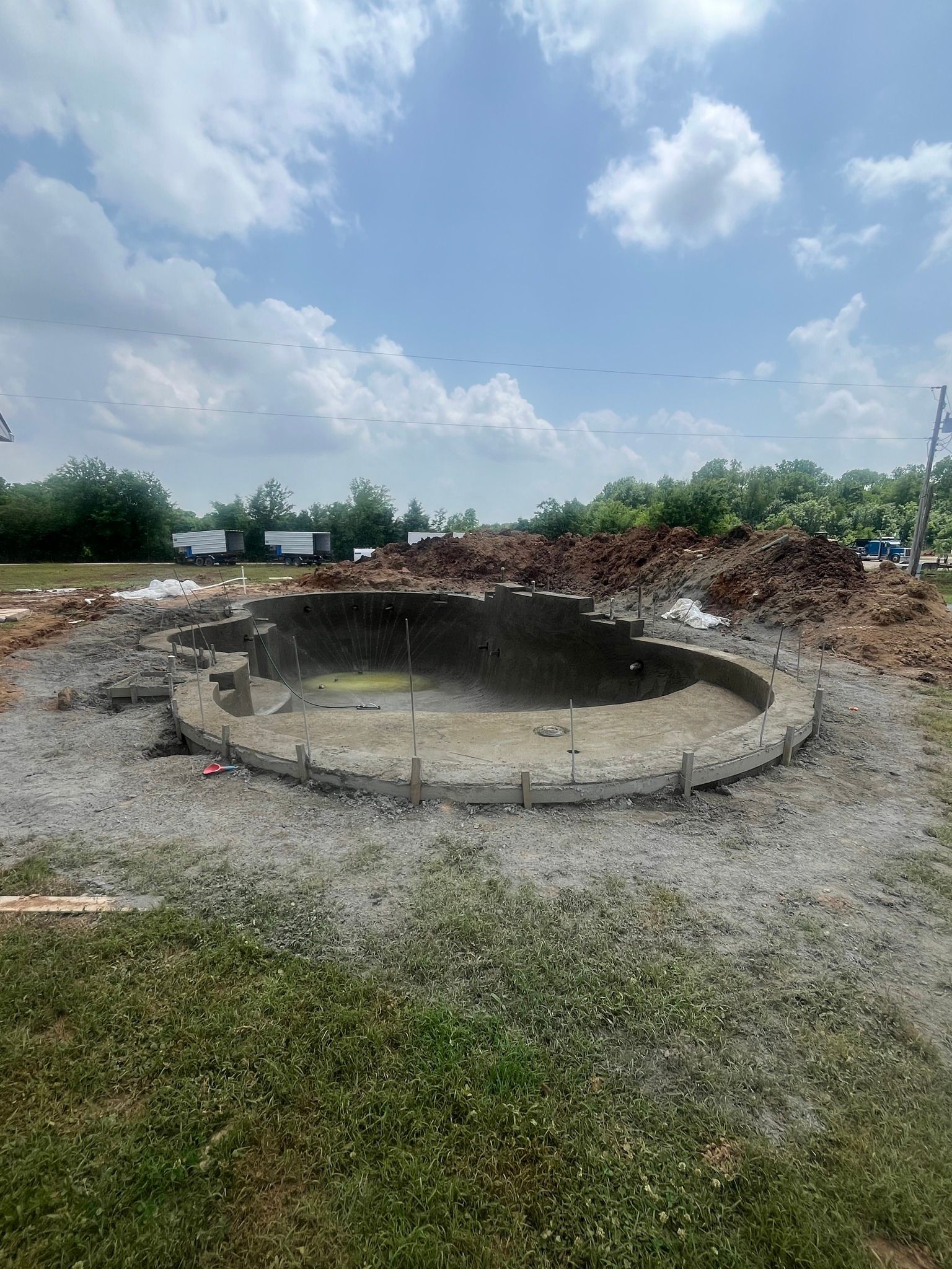 A large pool is being built in the middle of a grassy field.