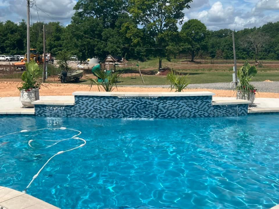 A large swimming pool with a waterfall in the middle of it.
