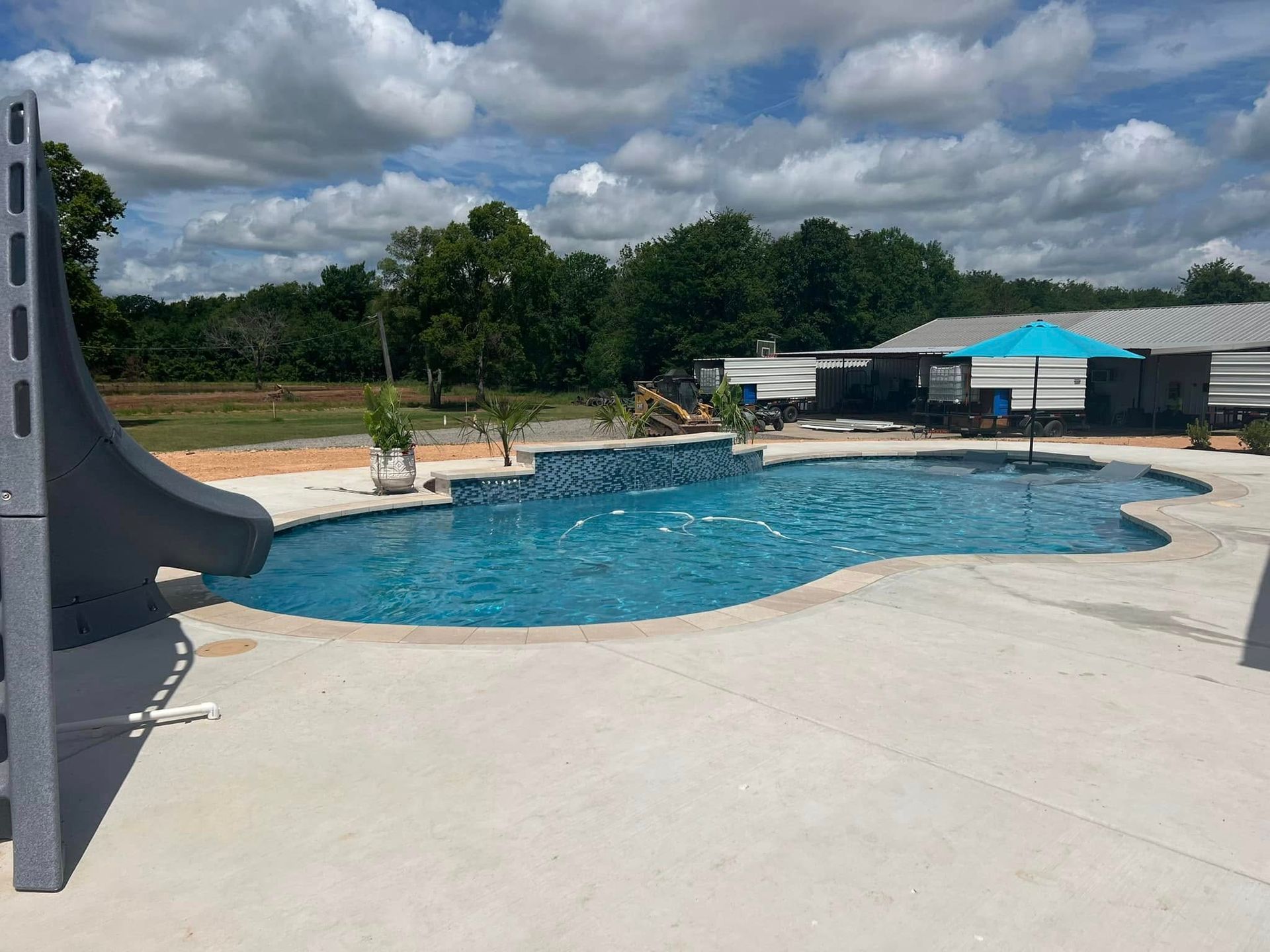 A large swimming pool with a slide in the middle of it.