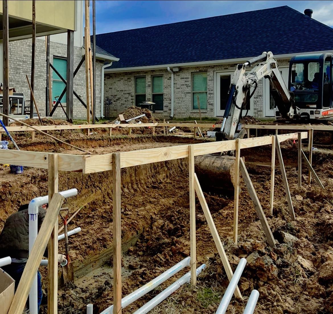 A construction site with a house in the background
