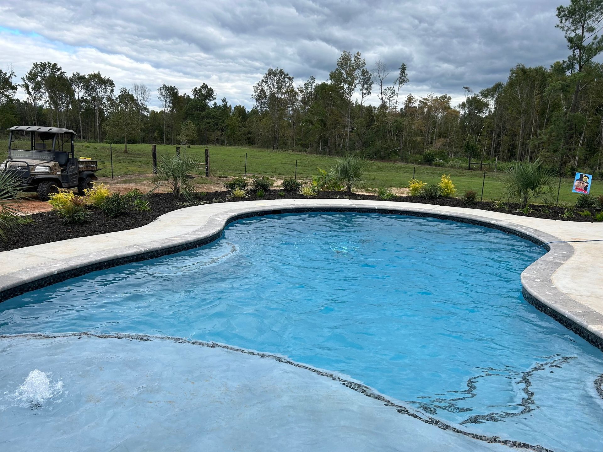 A large swimming pool with a golf cart in the background.
