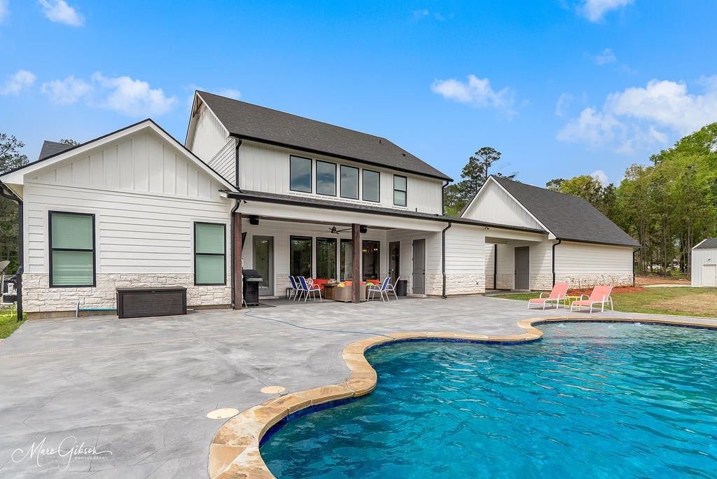 A large white house with a swimming pool in front of it.