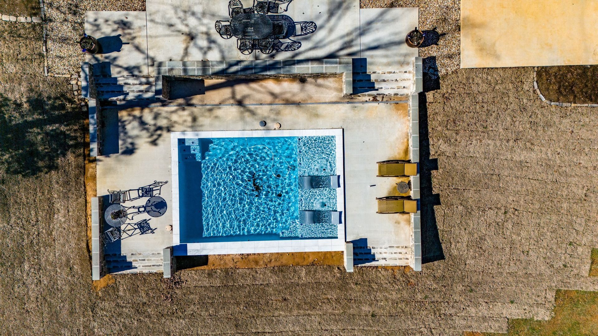 An aerial view of a large swimming pool in a backyard.