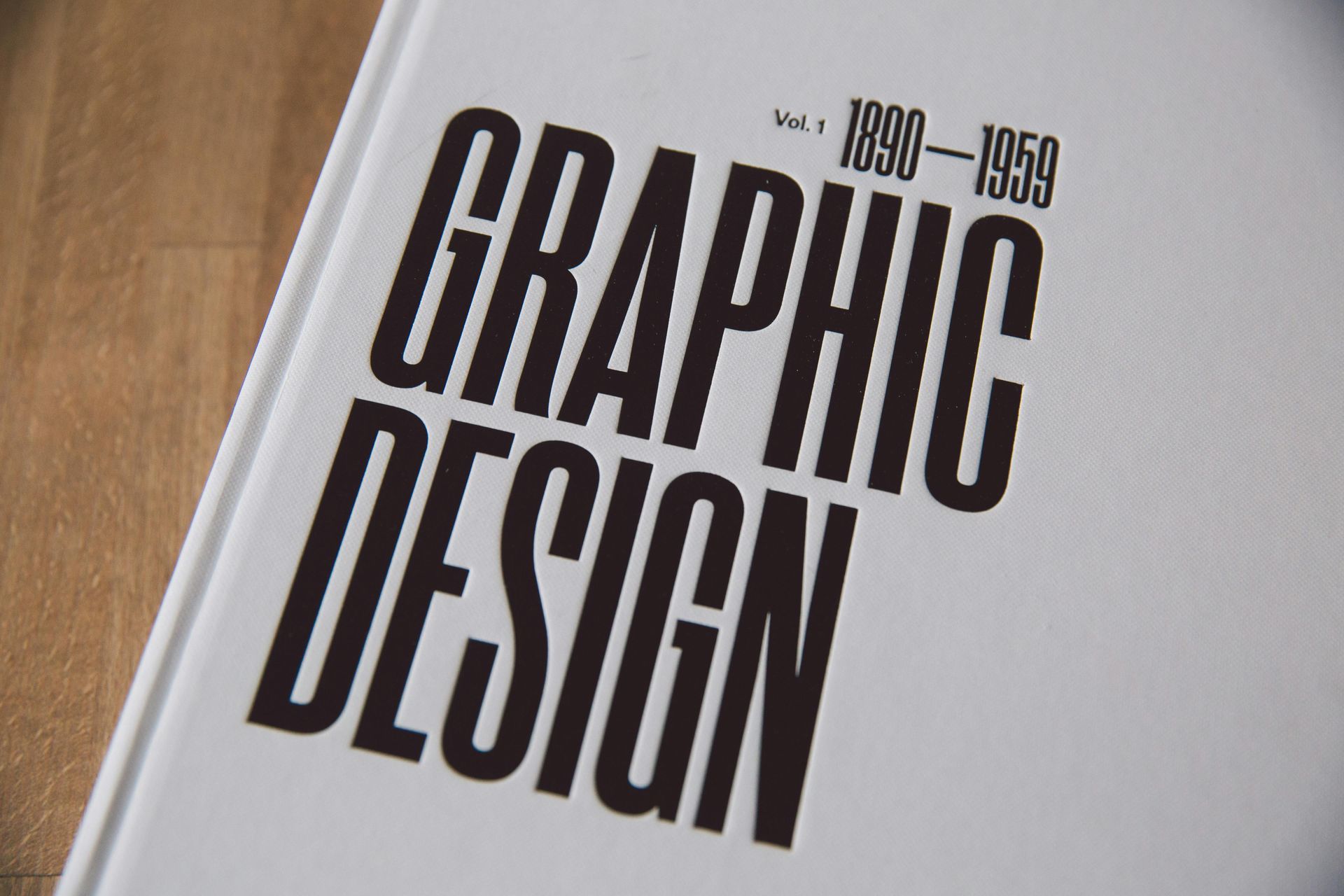 A book titled graphic design is on a wooden table