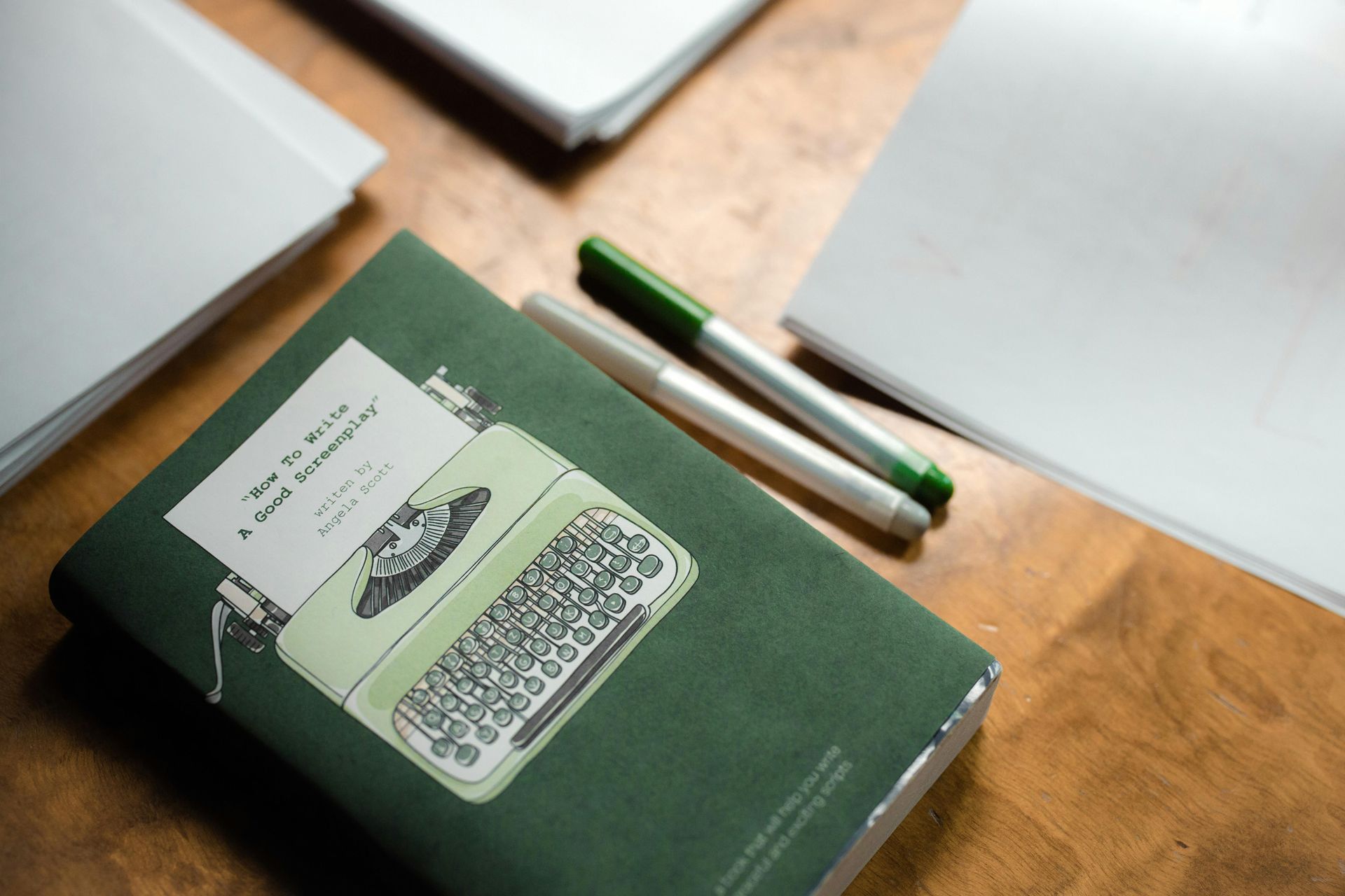 A green book with a typewriter on the cover