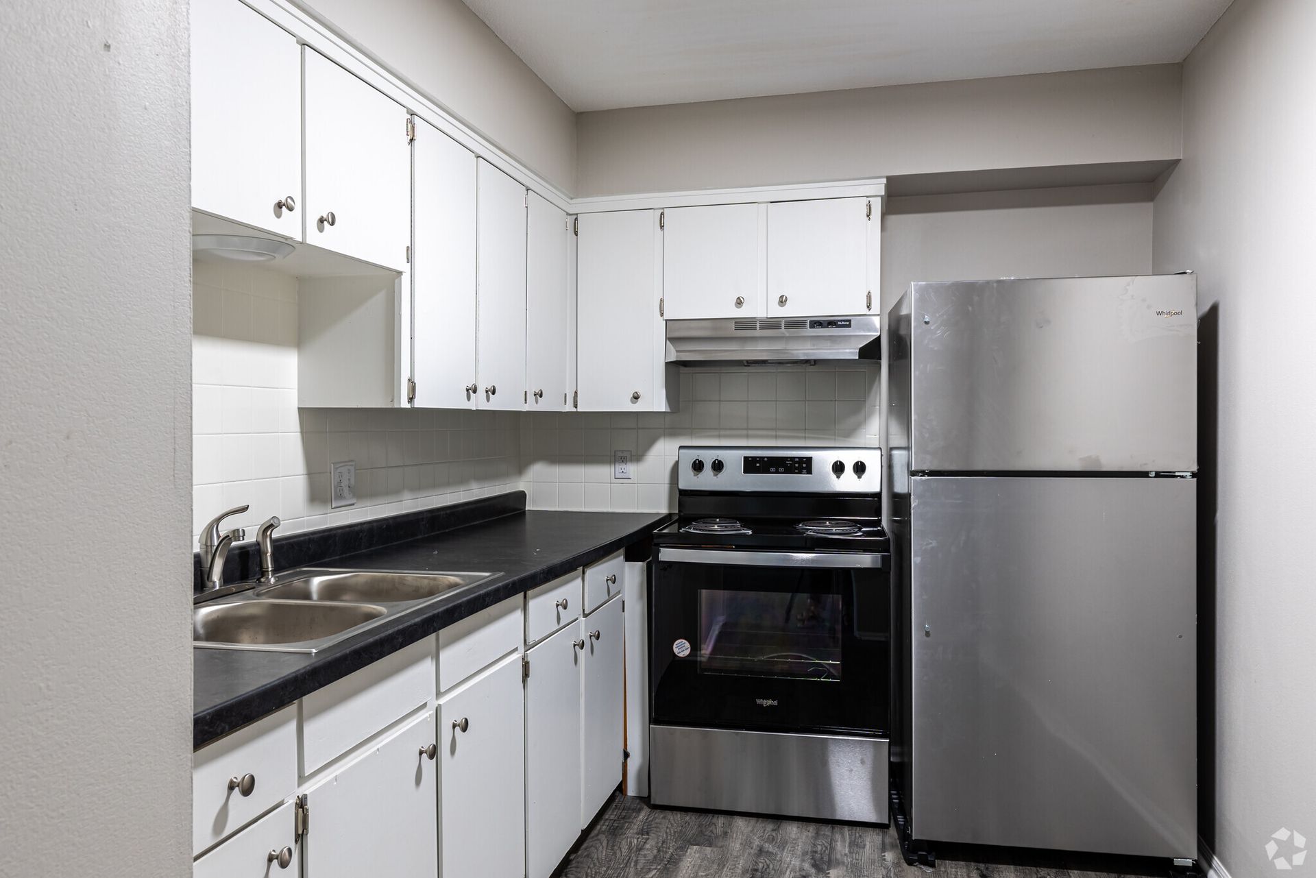 A kitchen with stainless steel appliances and white cabinets