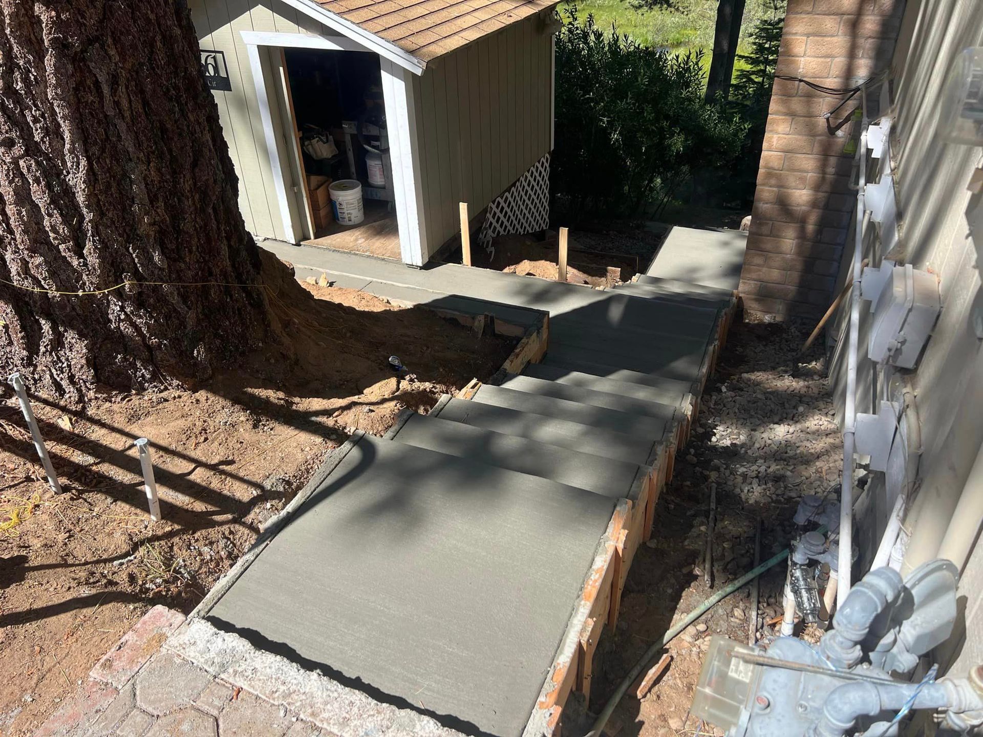 A concrete walkway is being built in front of a house.
