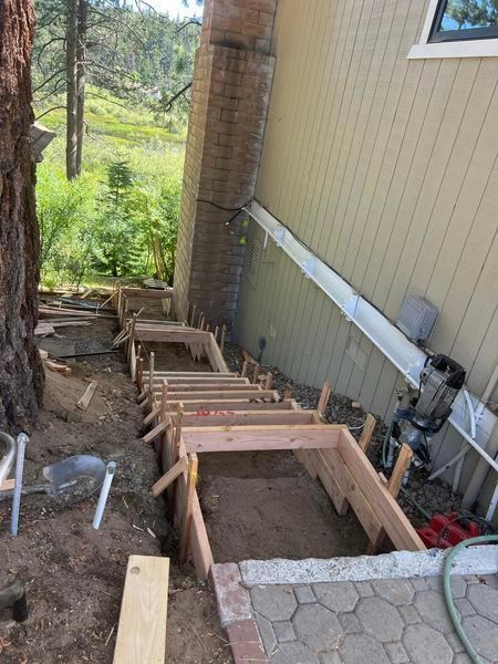 A wooden staircase is being built in front of a house.