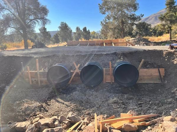 A construction site with a lot of pipes in the dirt