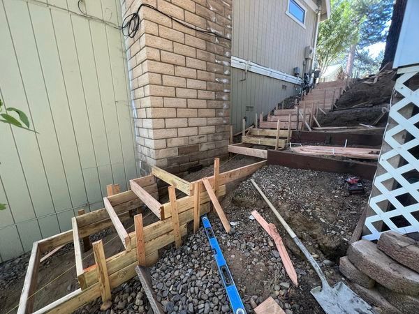 A staircase is being built in the backyard of a house.