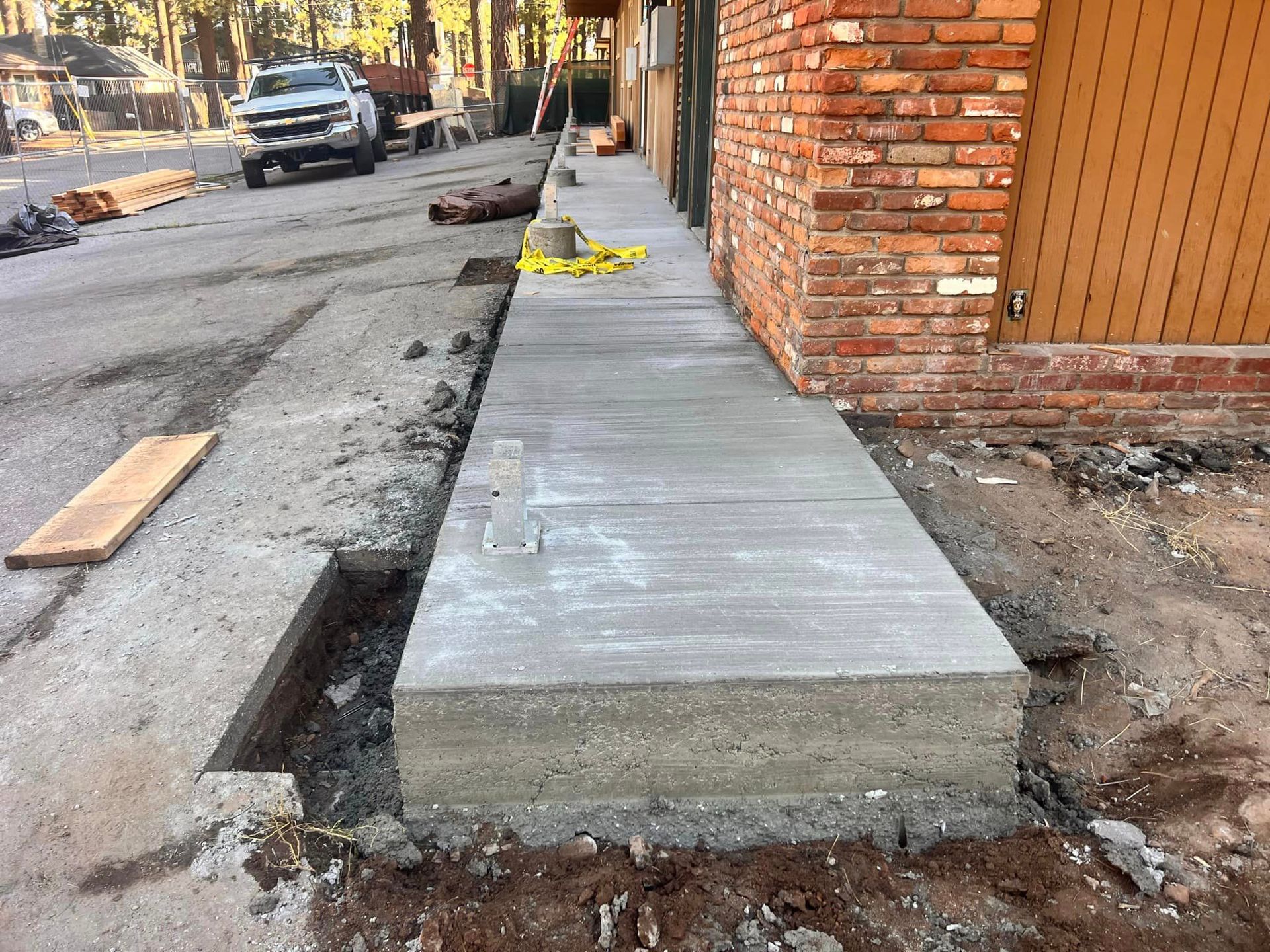 A concrete walkway is being built in front of a brick building.