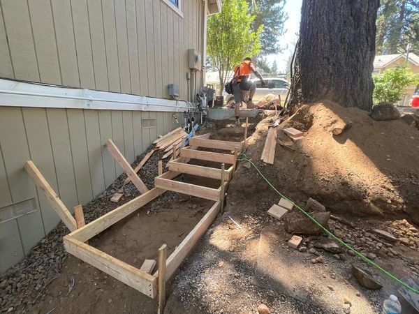 A wooden staircase is being built in front of a house.