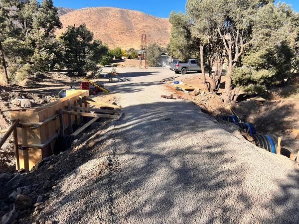 A road is being built in the desert with mountains in the background.
