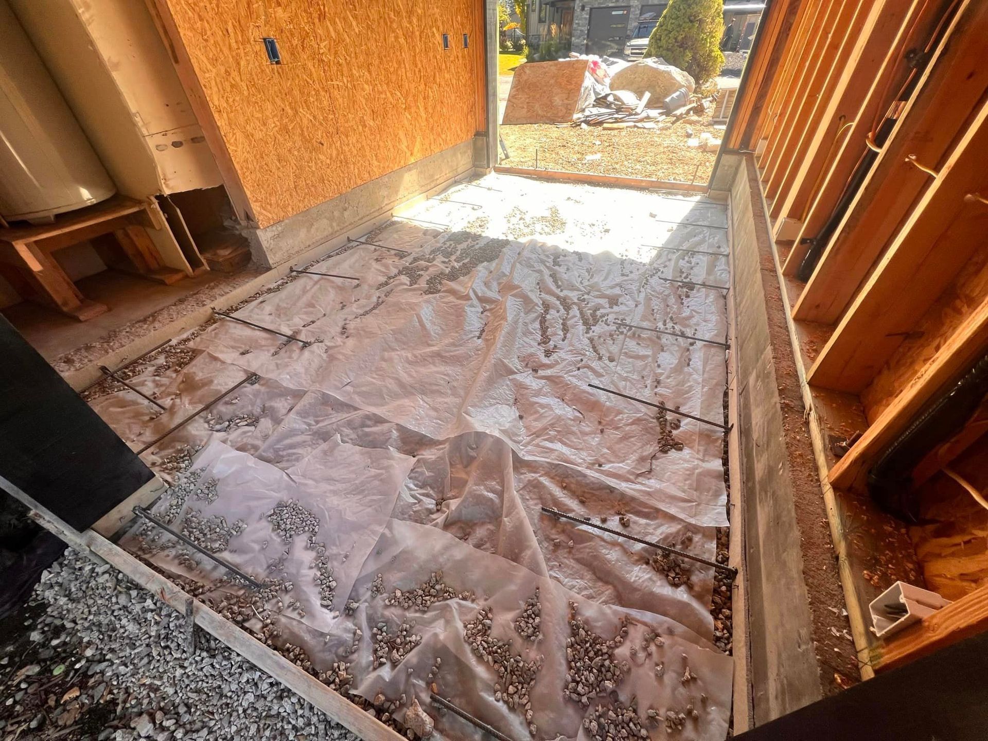 A concrete floor is being installed in a garage under construction.