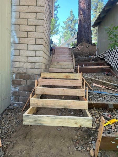 A wooden staircase is being built in front of a brick building.