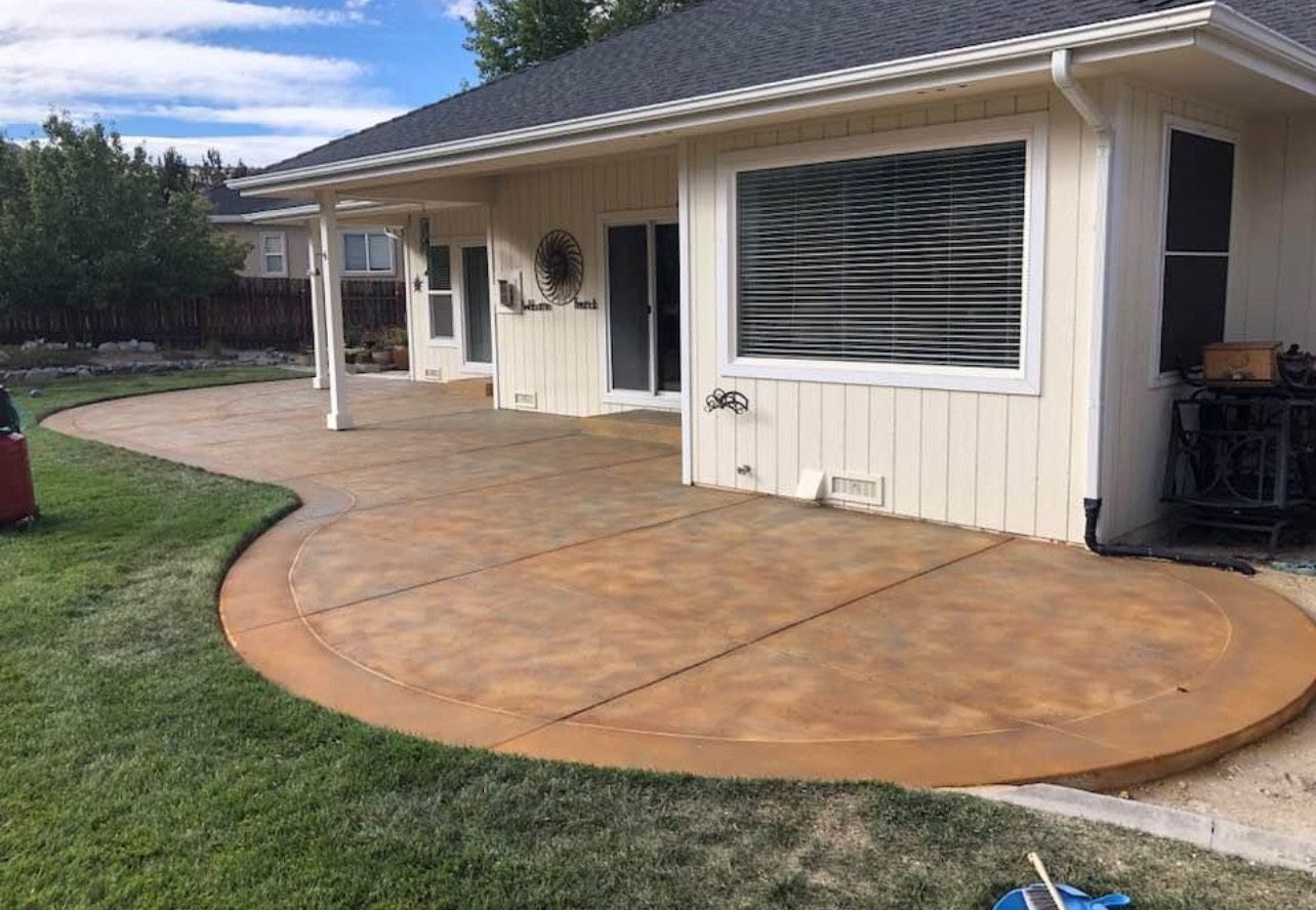 A white house with a concrete patio in front of it.