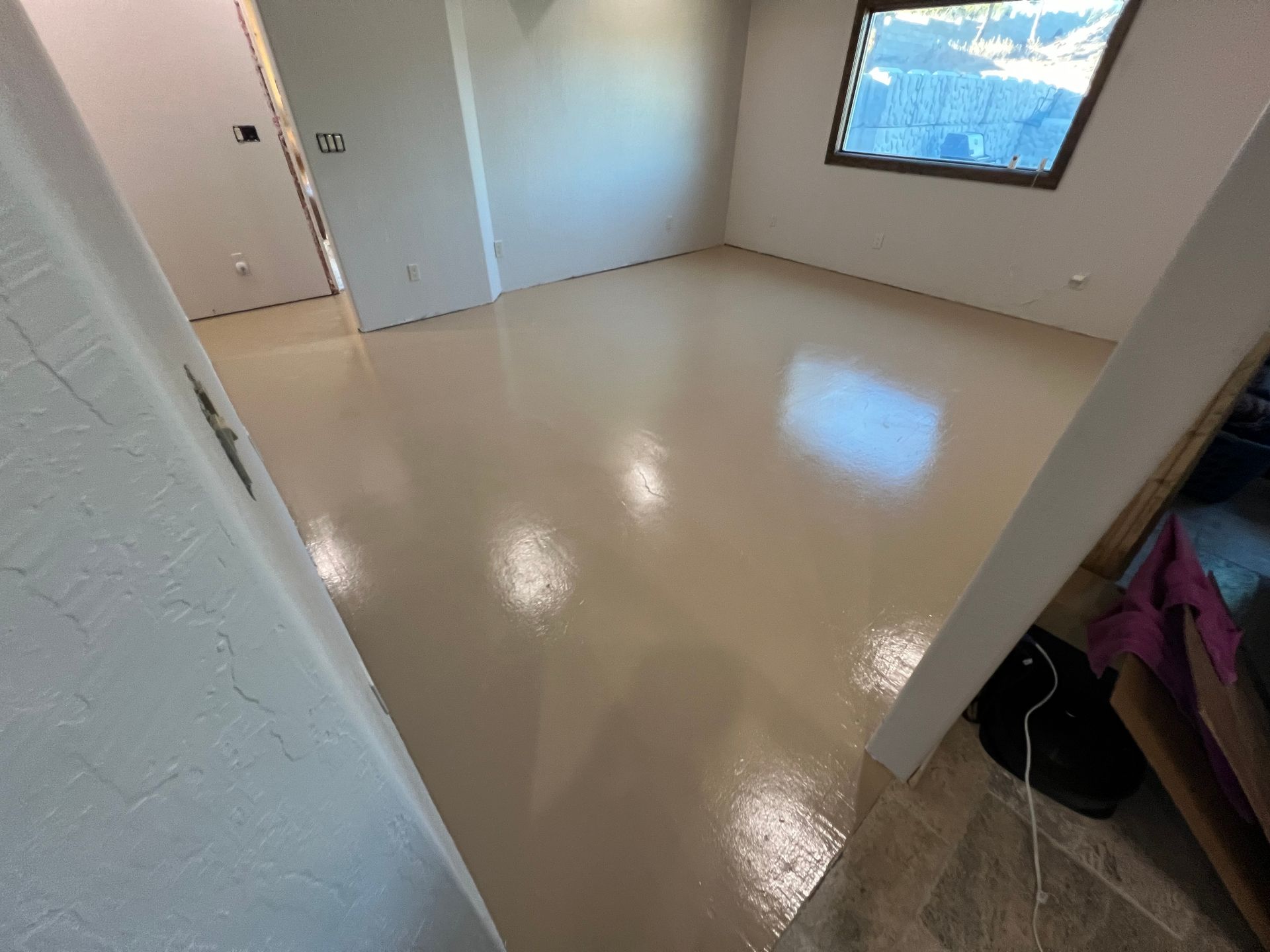 A room with a white floor and a window.