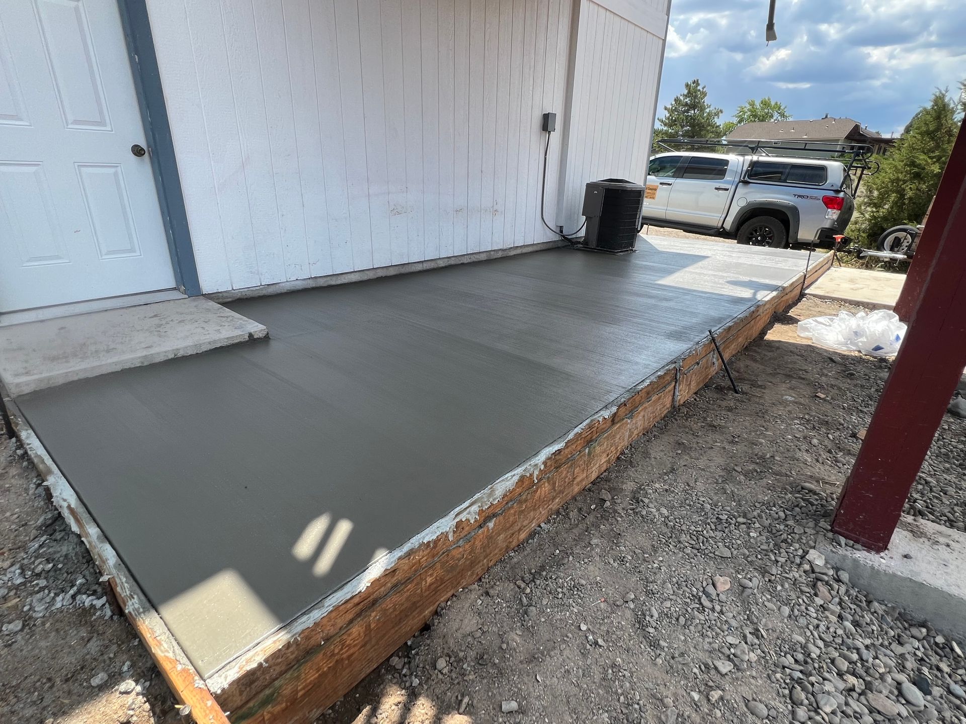 A concrete walkway is being built in front of a house.