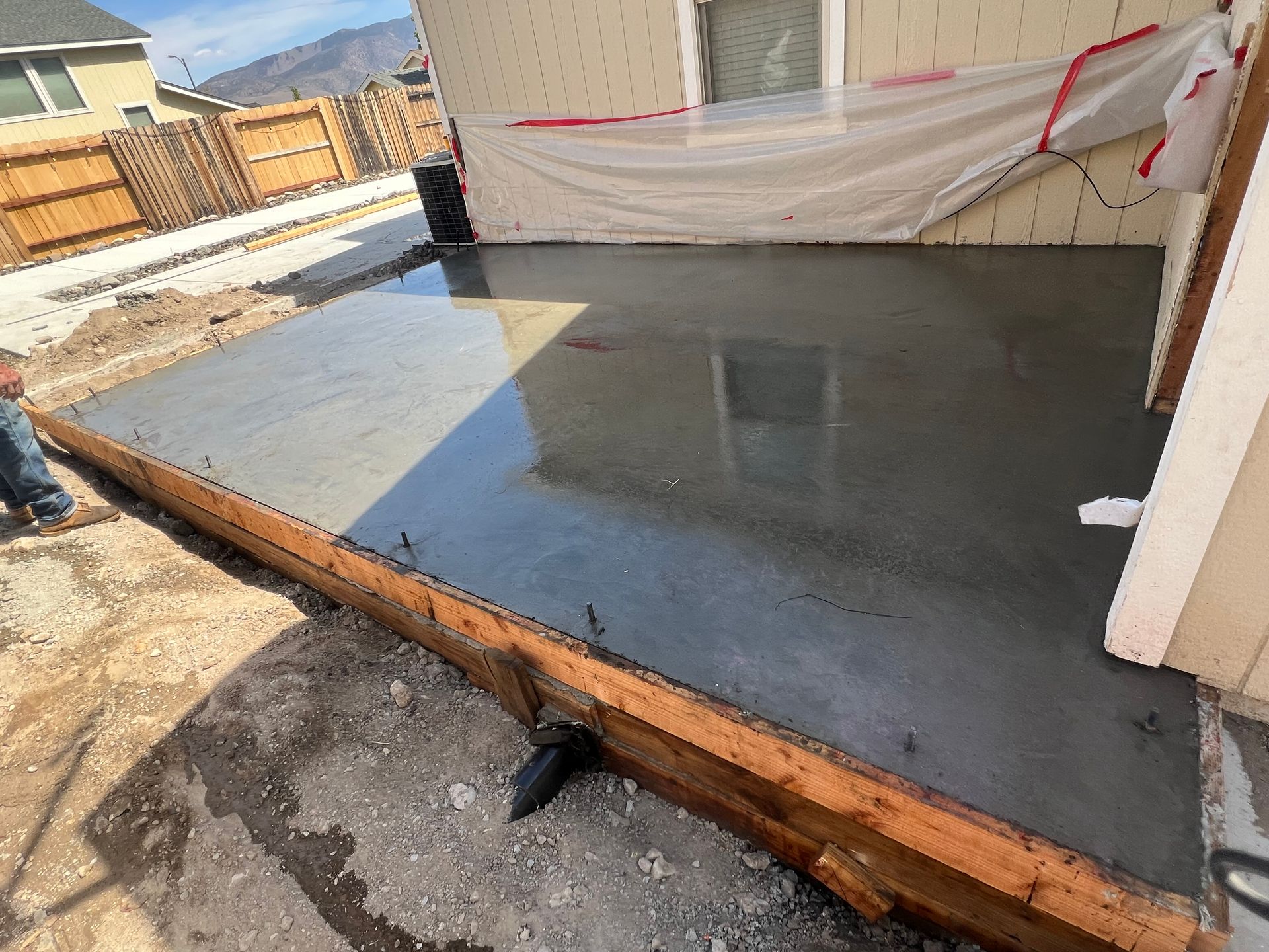 A concrete floor is being built in front of a house.