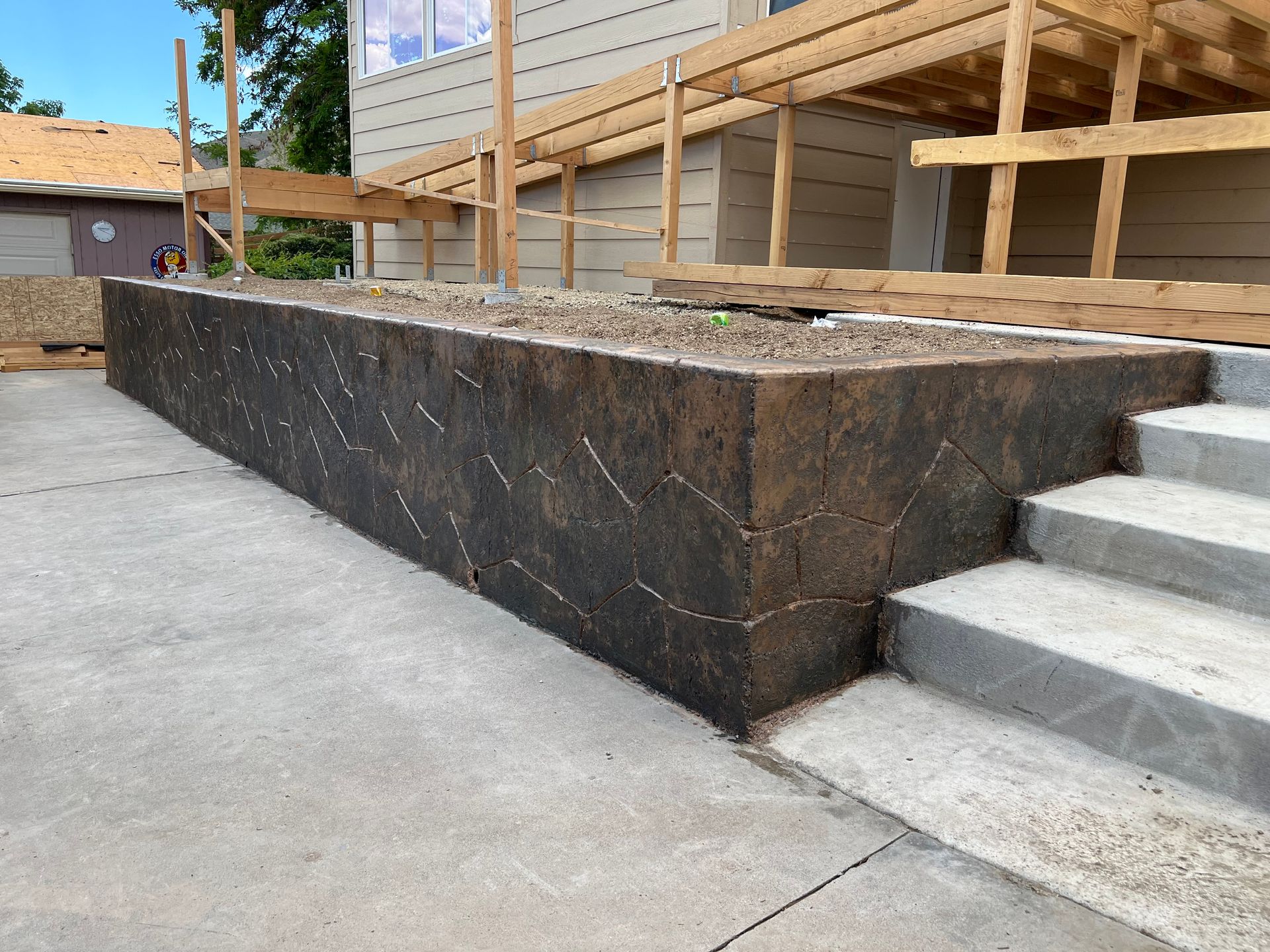 A concrete wall with stairs in front of a house under construction