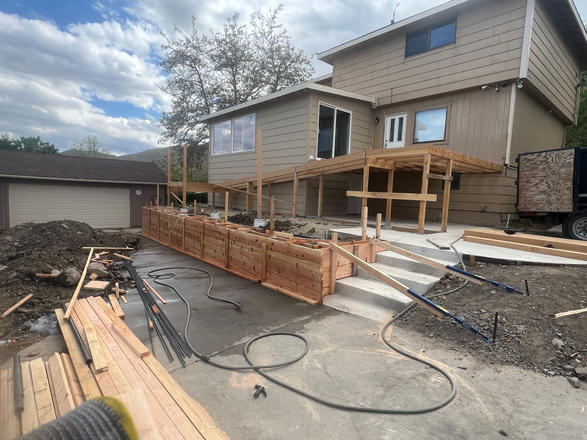 A house that is being built with a lot of wood in front of it