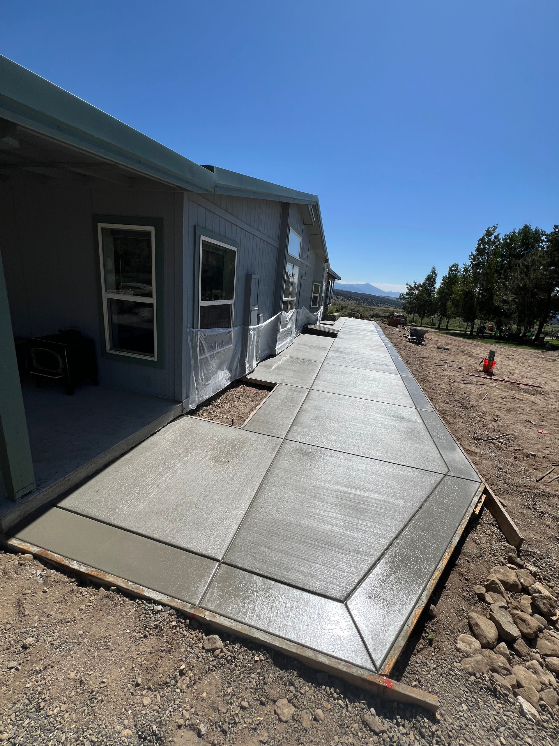 A concrete walkway is being built in front of a house.