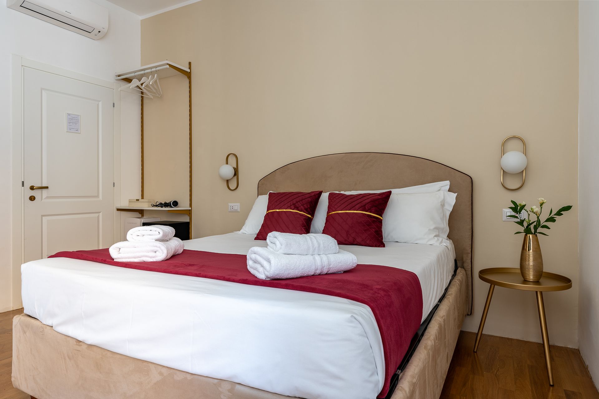 A hotel room with a king size bed and a table.