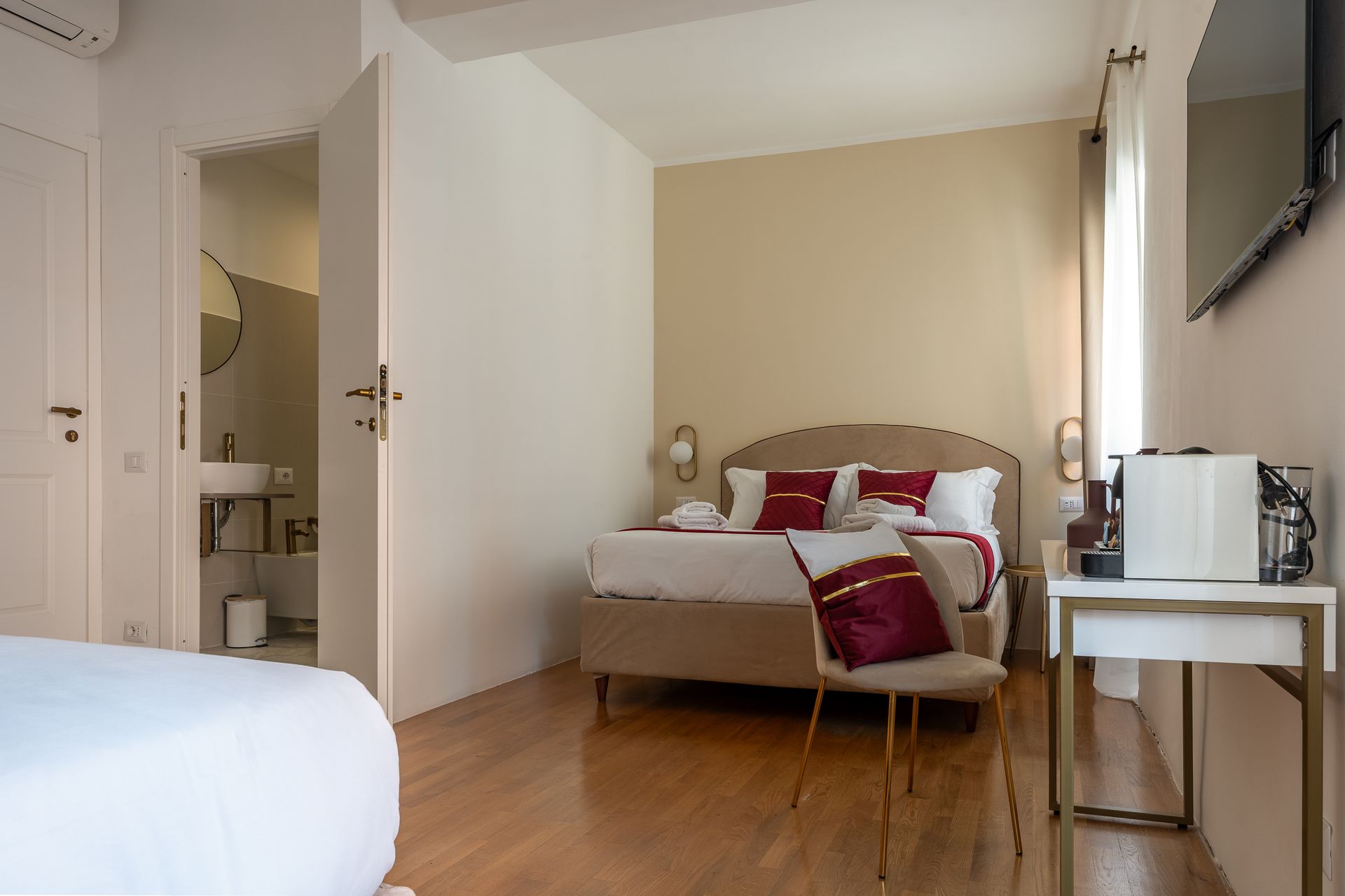 A hotel room with a bed , desk and television