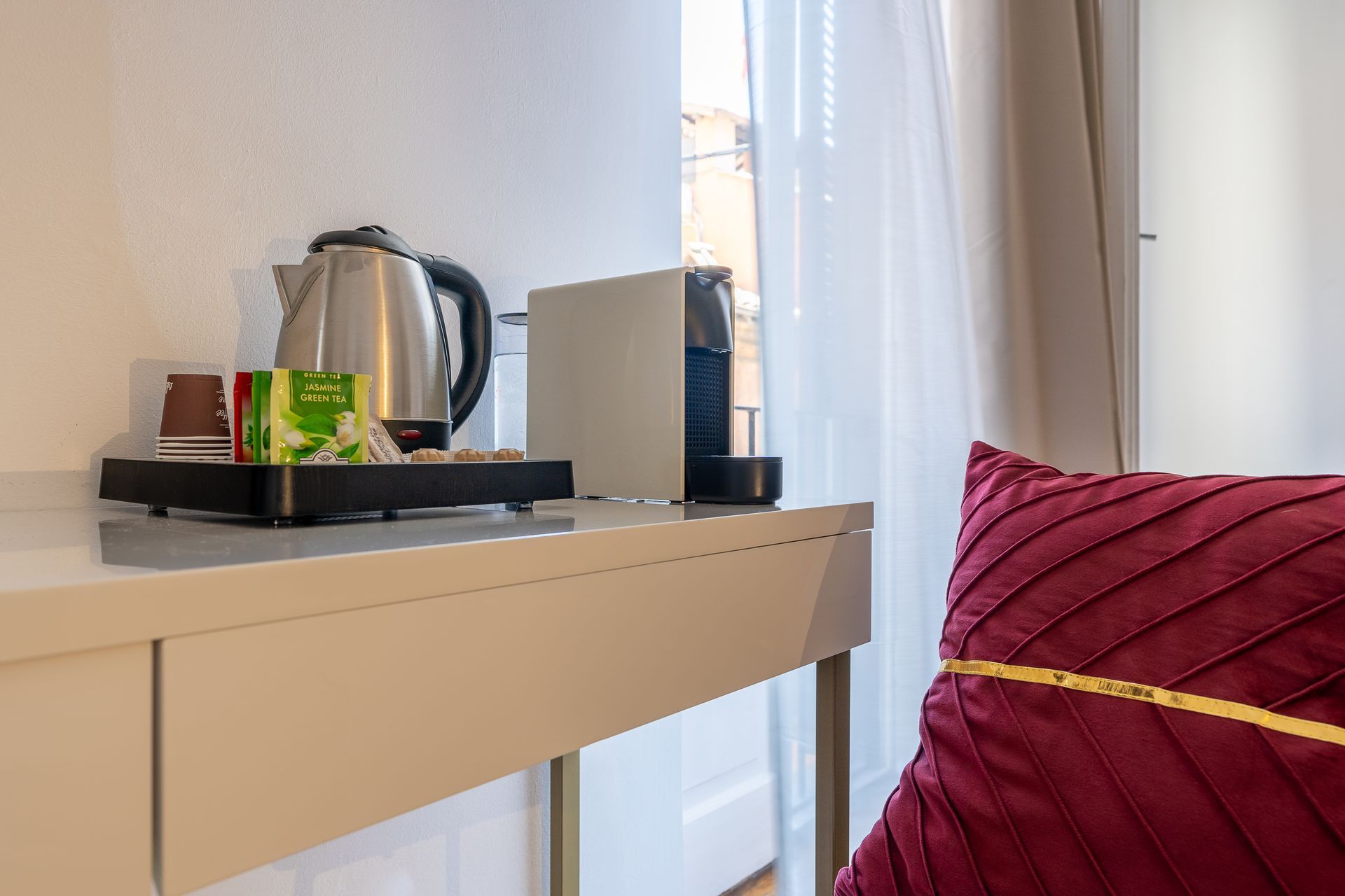 A white desk with a kettle and a toaster on it.