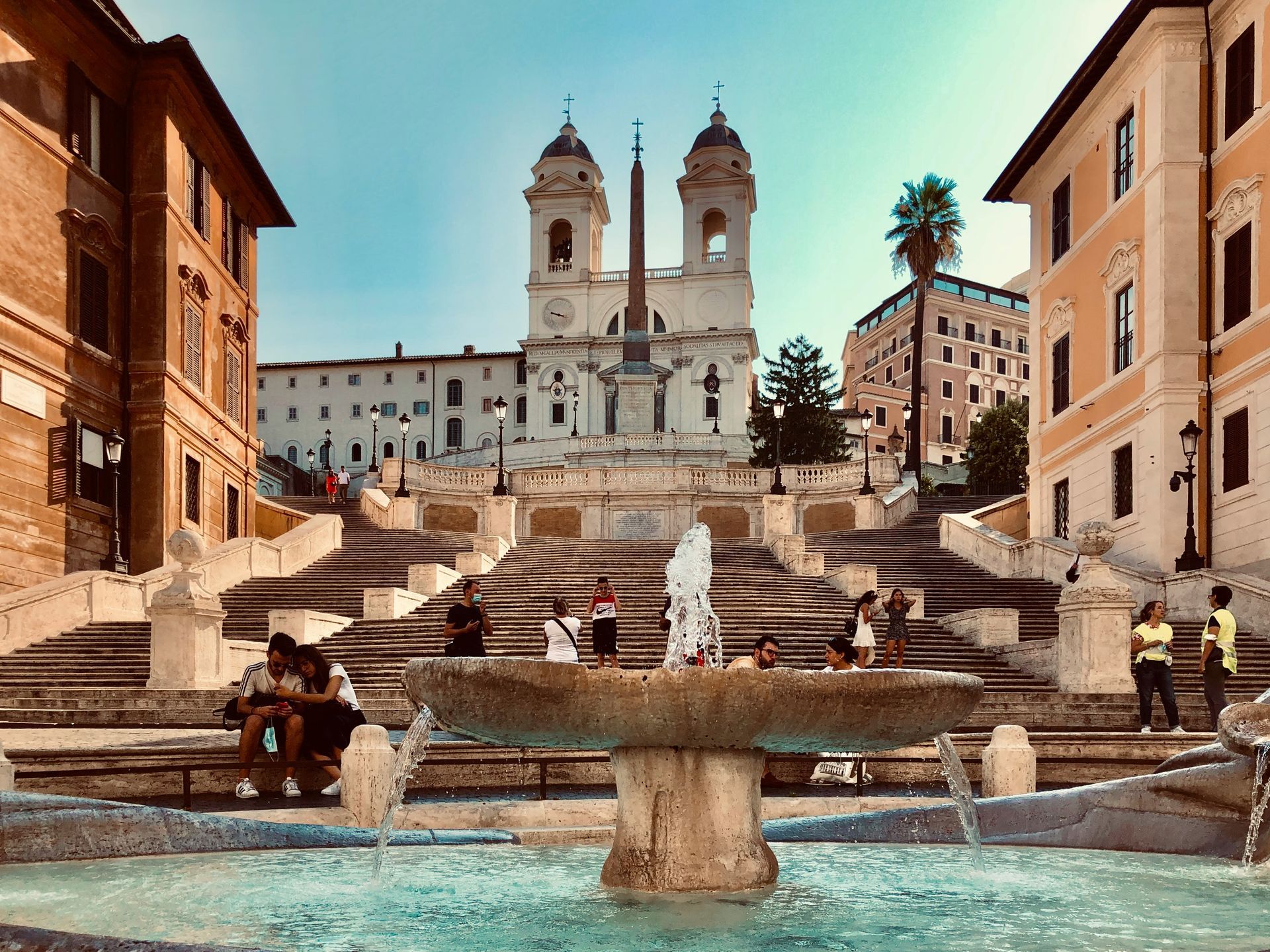 A fountain in front of a staircase with a church in the background