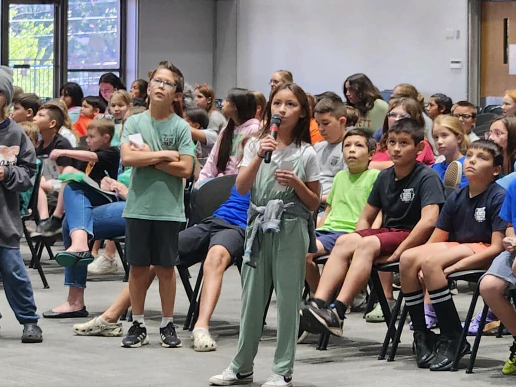 A group of children are standing in a classroom.