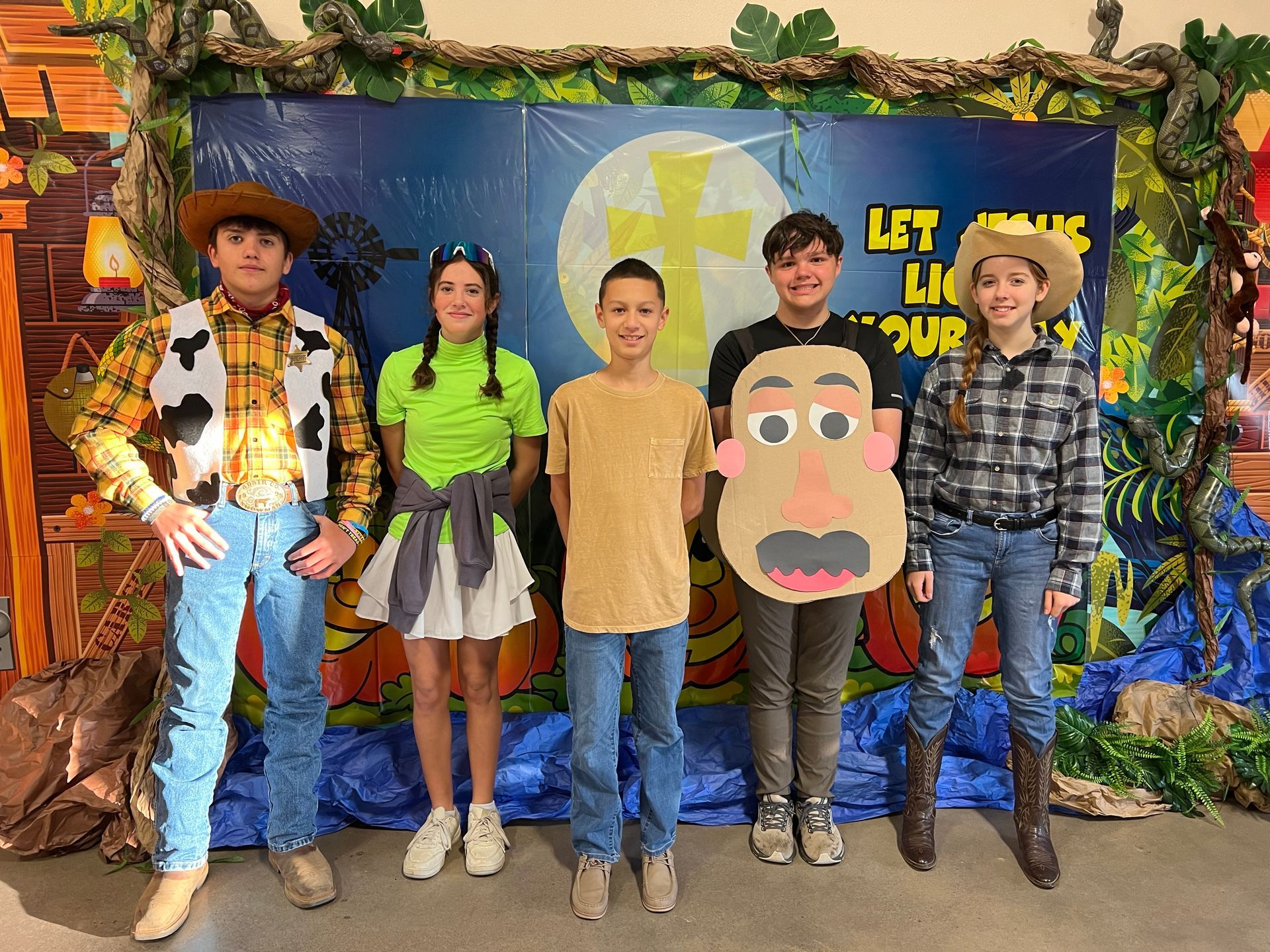 A group of children dressed in costumes are posing for a picture.
