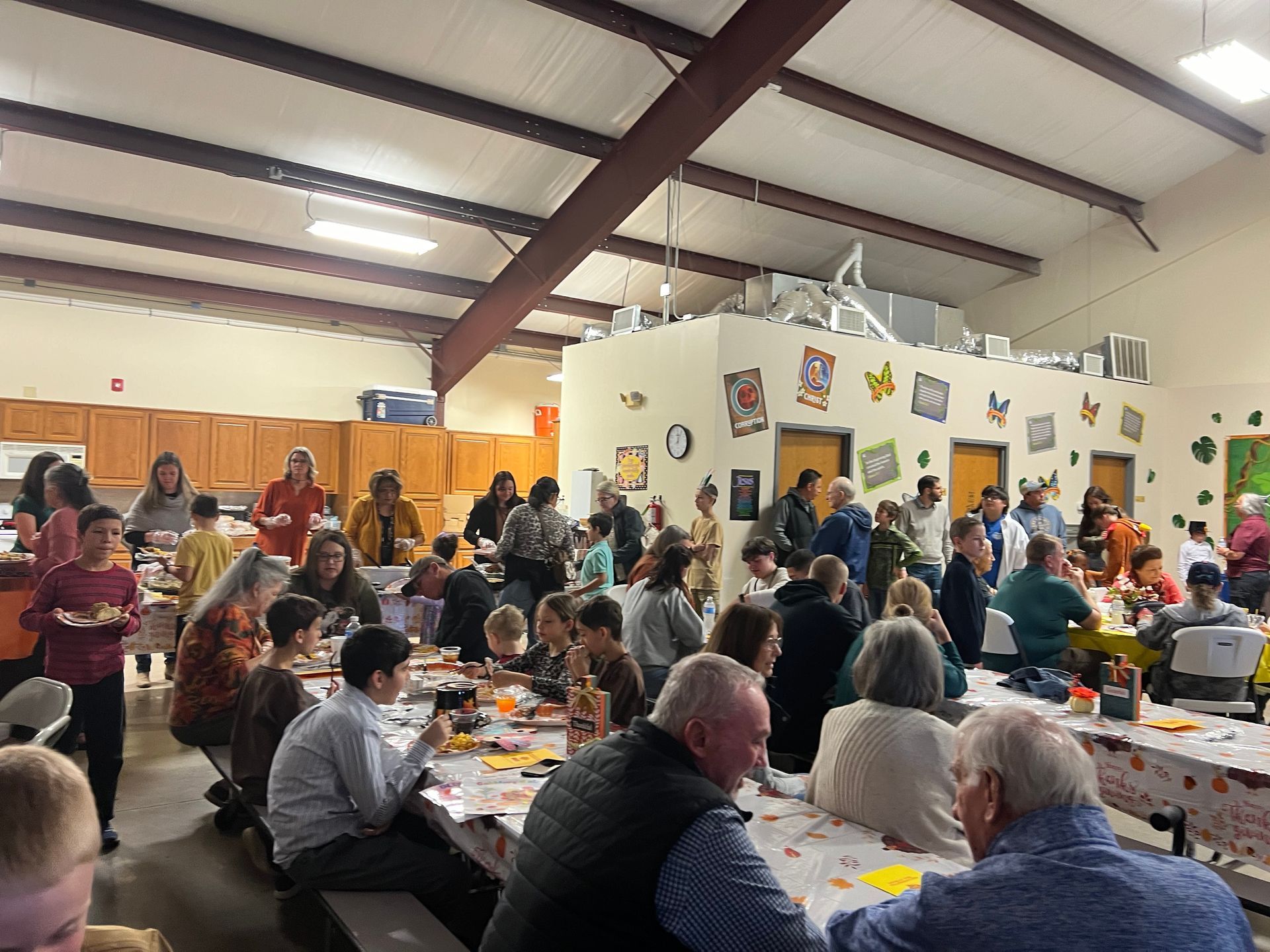 A large group of people are sitting at tables in a large room.