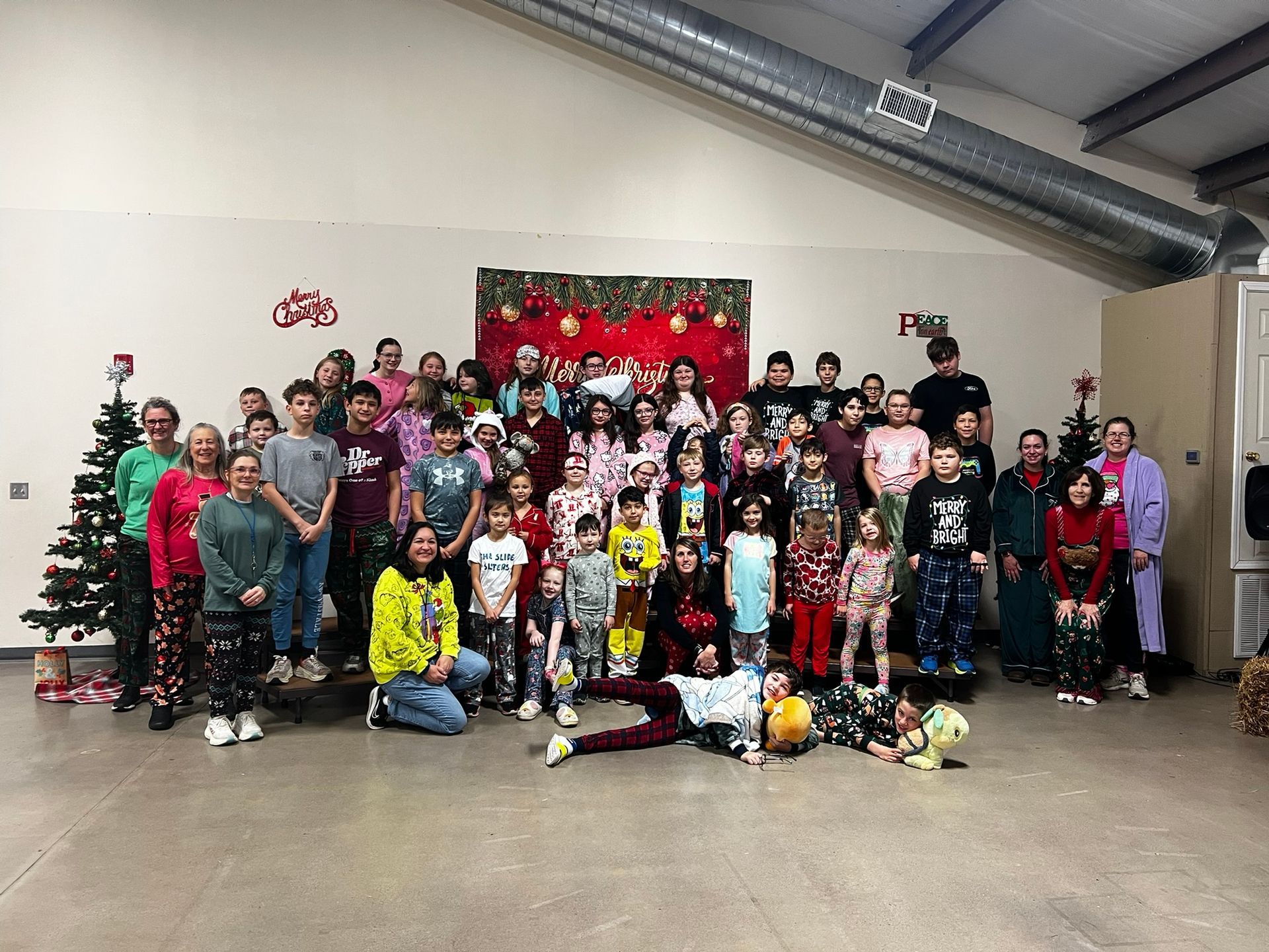 Group of people in pajamas posing in front of festive decorations.