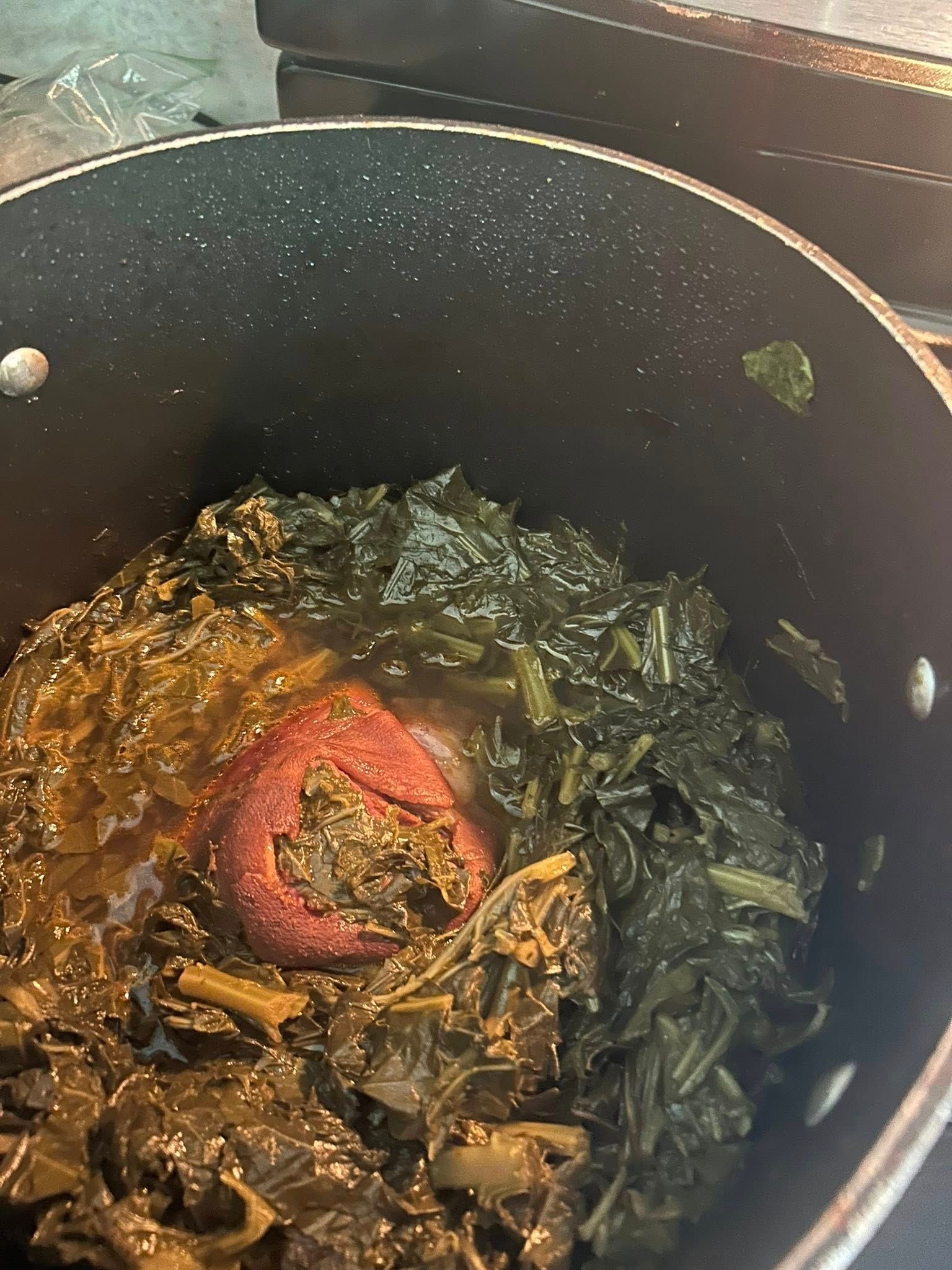 A pot filled with vegetables and tomato sauce on a stove.