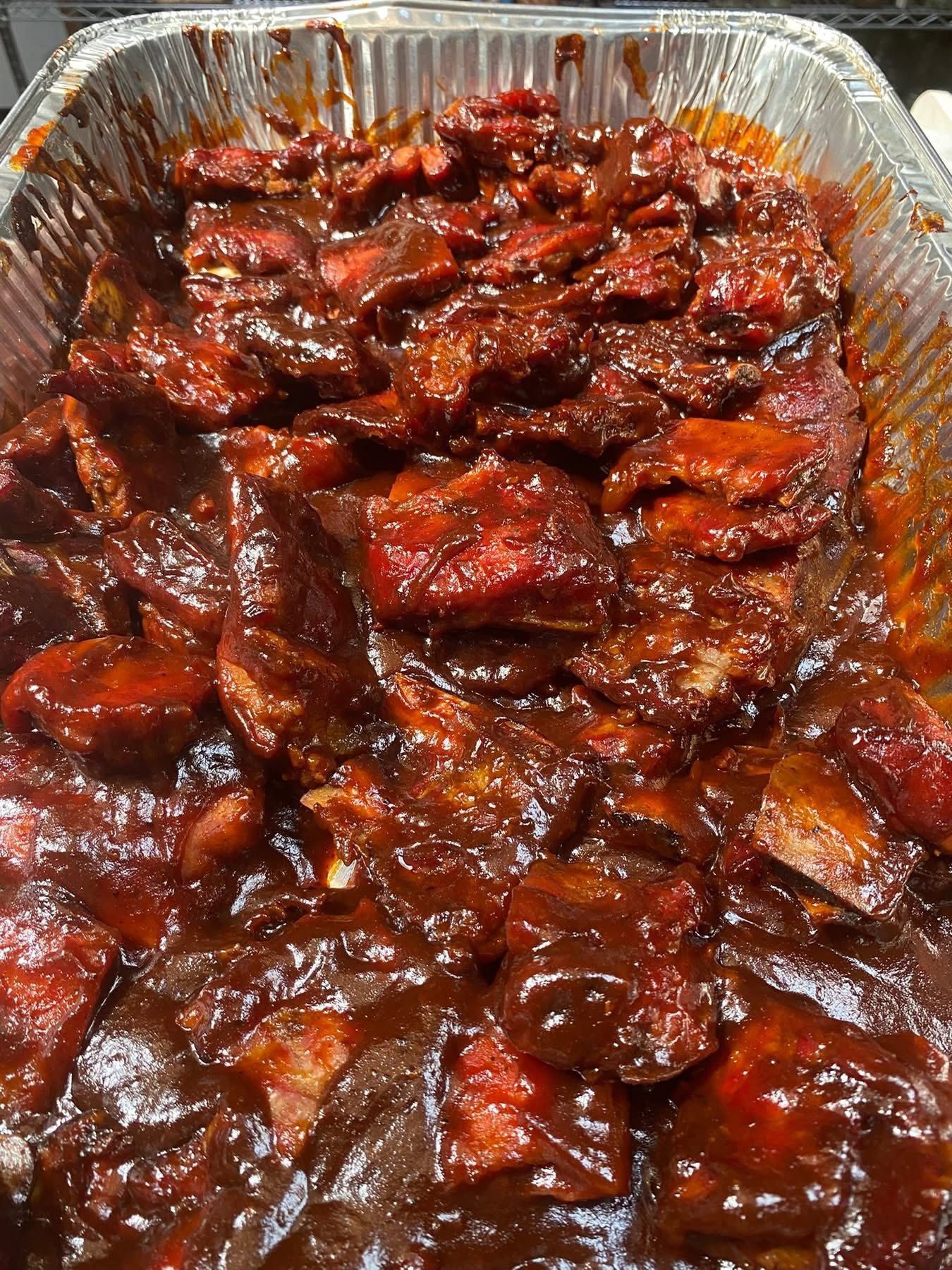 A pan filled with meat and sauce is sitting on a table.