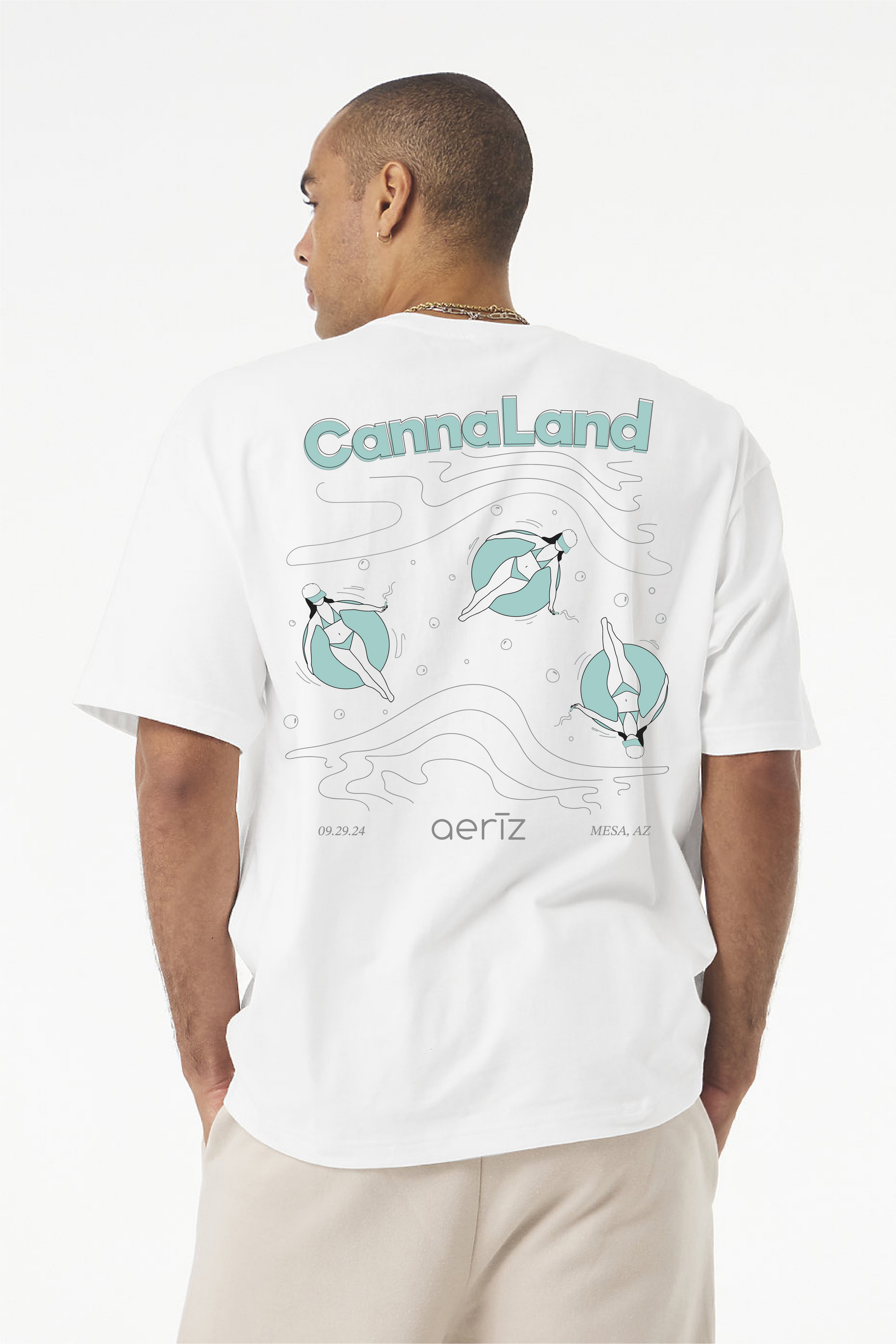 A man is wearing a white t-shirt with a mint green/gray design on the back.