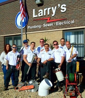 A group of men standing in front of a building that says larry 's plumbing sewer electrical