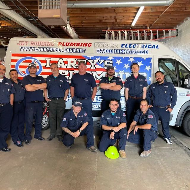 A group of men pose in front of a larry 's plumbing van