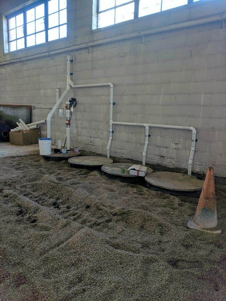 A room with a lot of pipes and cones on the floor.