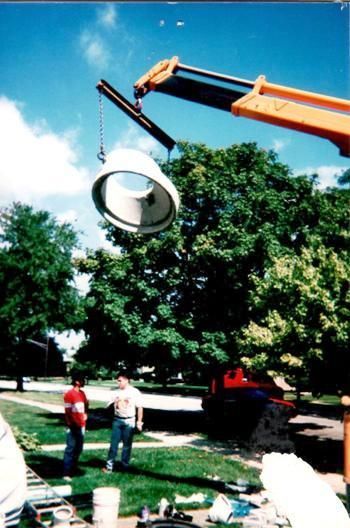 A crane is lifting a white object in a park