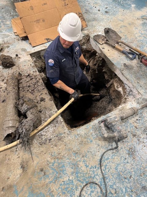 A man is digging a hole in the ground with a shovel.