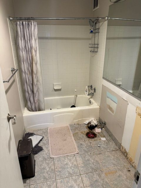 A bathroom with a bathtub and a shower curtain.