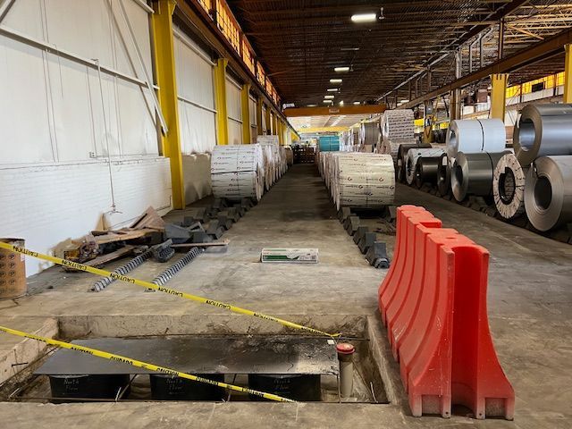 A warehouse filled with lots of rolls of metal