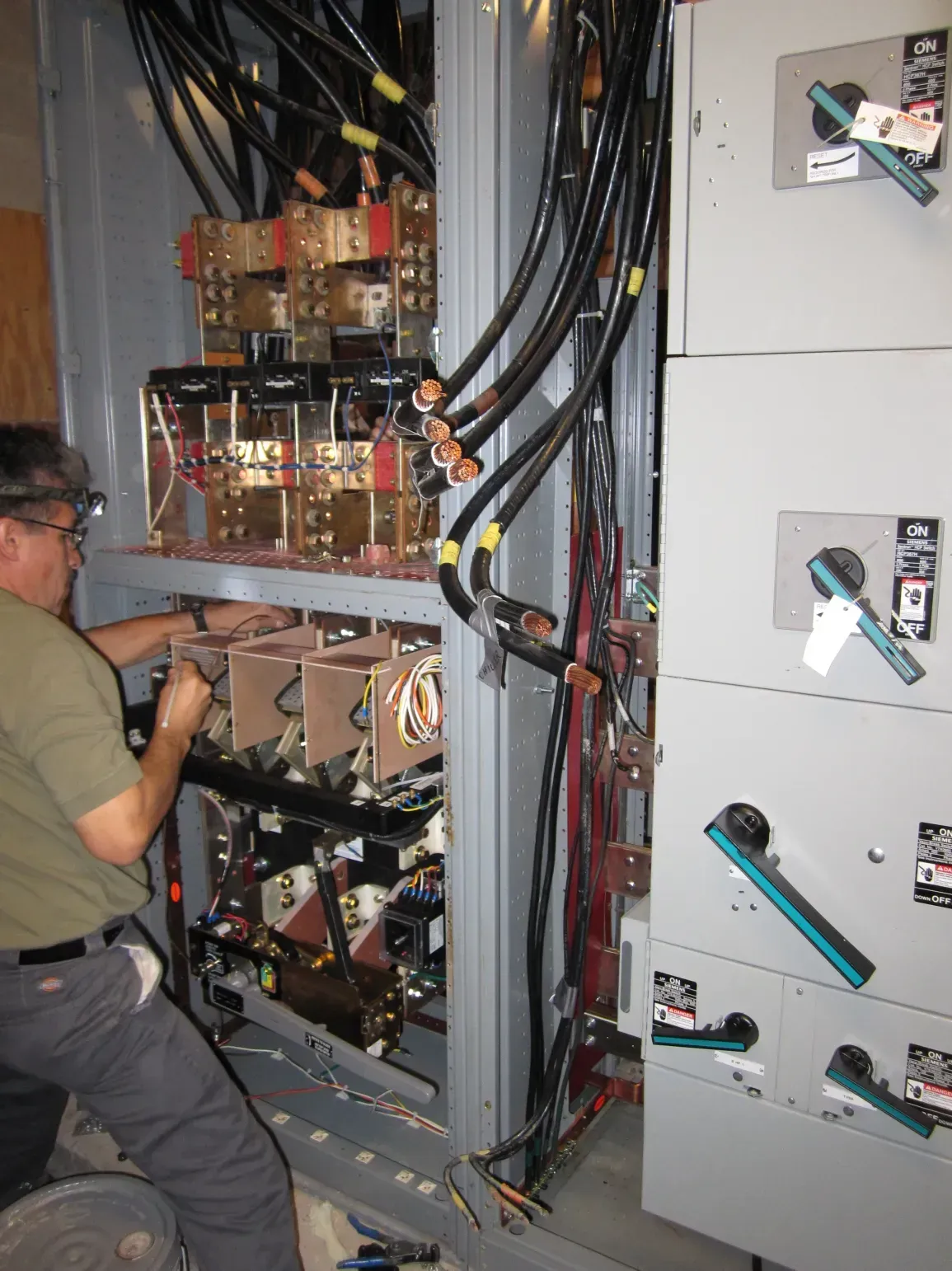 A man is working on a large electrical box
