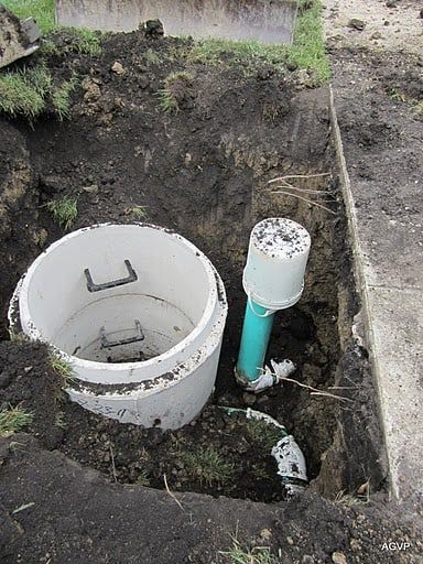 A septic tank is being installed in a hole in the ground.