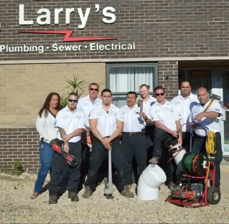 A group of people standing in front of a building that says larry 's plumbing sewer electrical