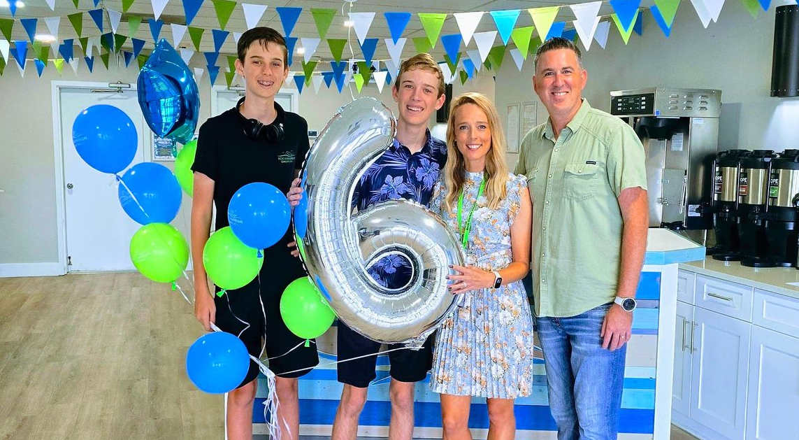 A man , woman , two boys and a girl are posing for a picture.