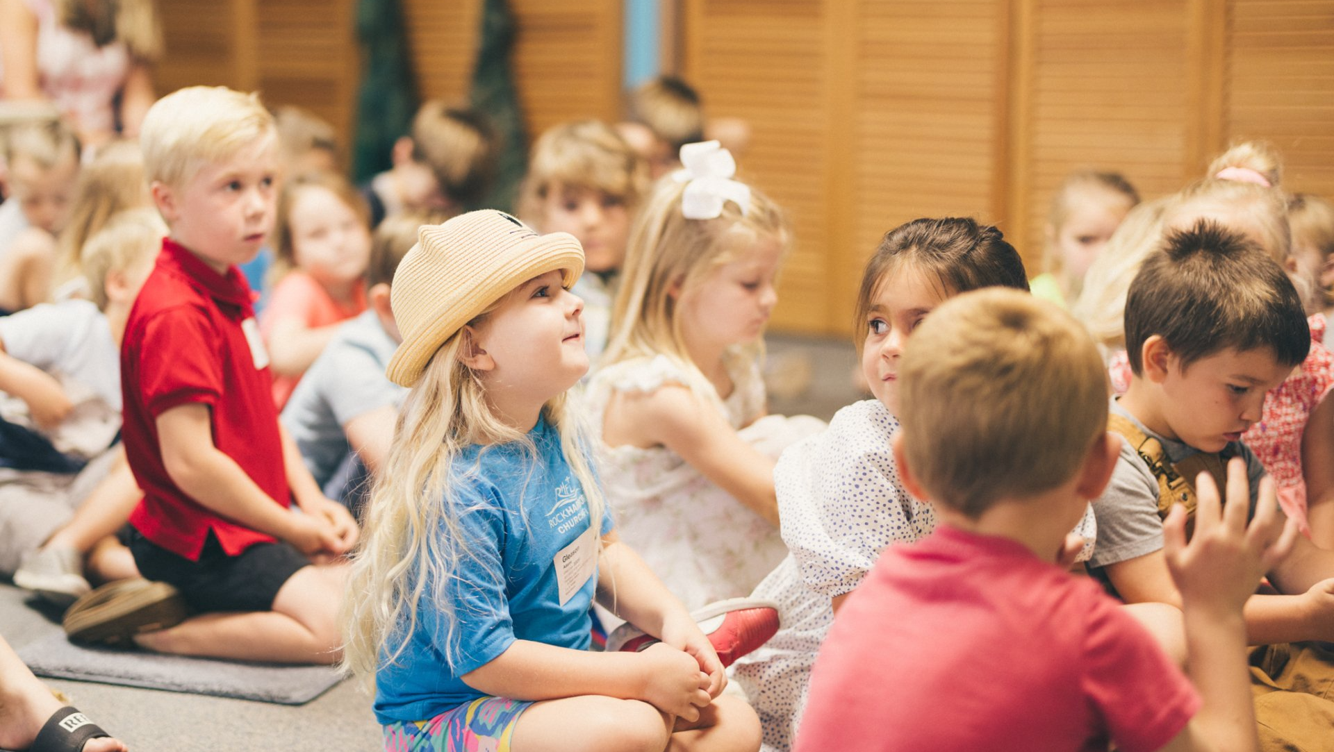 A group of children are sitting on the floor in a room.